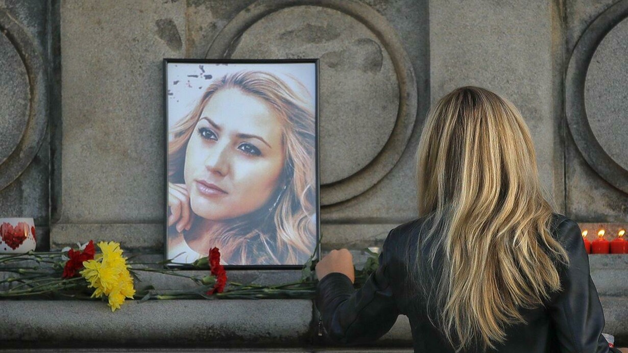 Una joven deja flores ante el retrato de Viktoria Marinova