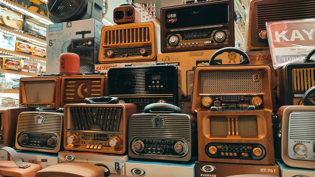 Loja vende rádios antigos. Do mesmo modo que a televisão está sendo aniquilada pelo streaming, os canais televisivos realizaram o mesmo processo com uma mídia mais antiga: eram os chamados radio dramas, que entretinham as famílias antes que fosse possível comprar aparelhos de televisão para suas casas. Ainda que hoje estejam completamente esquecidos, foram um elemento importante da cultura pop durante o começo do século