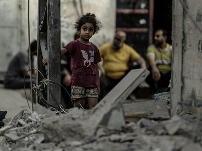 Una niña mira a la cámara entre los escombros en Gaza