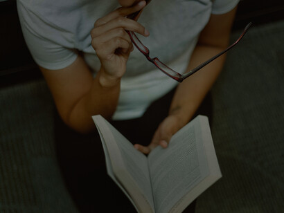 A woman sitting down studying with her book on her laps