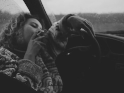 In a muted gray and white sweater, her countenance reflecting a mood tinged with melancholy