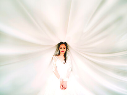 Mujer vestida de novia con el velo extendido. A la hora de elegir el estilo del vestido, es importante que vaya acorde con el tipo de celebración