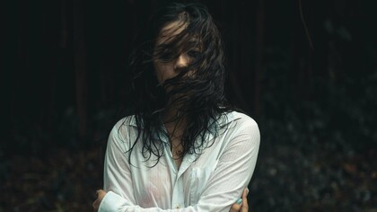 A woman drenched and looking drained, symbolising how some wounds take longer to heal and can pull you under the waves of grief at any moment