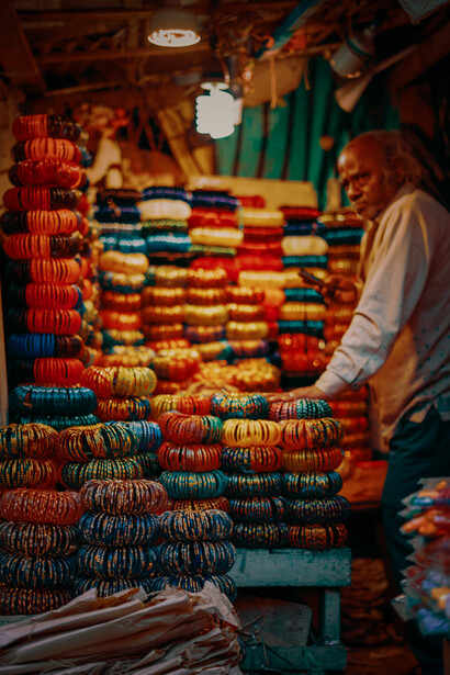 A man sells traditional goods at a bustling bazaar, India