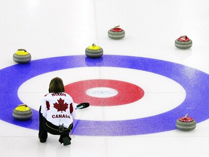 Jugadora de curling cepillando alrededor de la diana