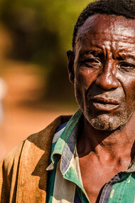 The weight of the world is etched in the lines of his face, a testament to a life shaped by hardship and struggle