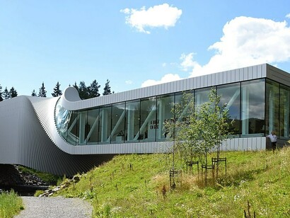 The Twist is a captivating fusion of gallery, bridge, and sculpture. Stretching 60 meters across the Randselva River in Norway, this 1,000-square-meter building seamlessly twists into a striking sculptural shape