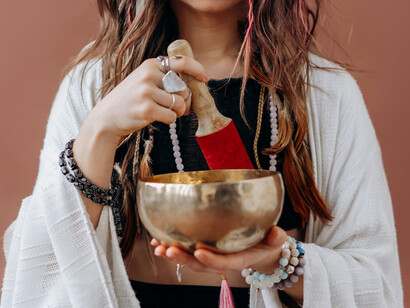 Close up of a woman playing a Tibetan bowl