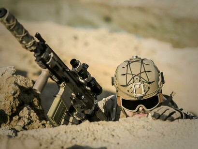 A soldier with a gun wearing a camouflage uniform 