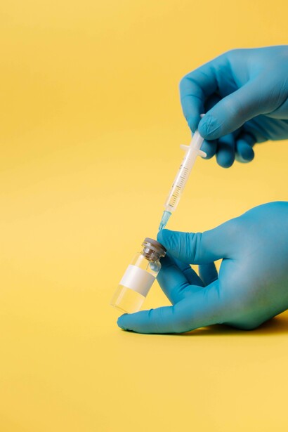 Man using a syringe to load up a vaccine