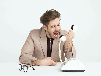 A customer yelling at the worker over the phone
