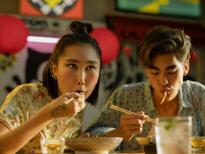 Asiatici mangiano cibo cinese con le bacchette