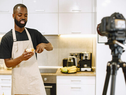 A content creator filming a cooking video, showcasing fresh lettuce as part of the recipe