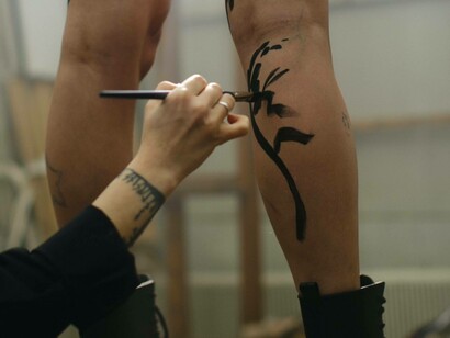 Artist paints on body art on legs
