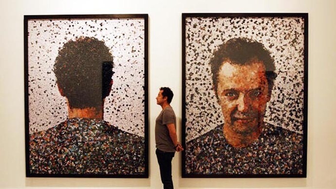 O artista brasileiro Vik Muniz no meio de dois autorretratos criados com papel recortados de revistas