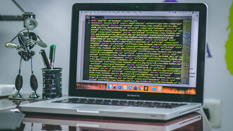 An open MacBook Pro displaying coding scripts, illustrating the integration of Web3 technologies