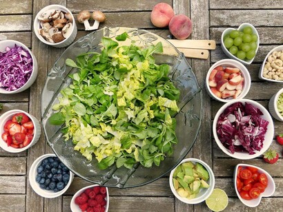 A giant bowl of lettuce is surrounded by tiny bowls of fruit and vegetables which can make for a lovely meal for either lunch or dinner and will help you lose weight