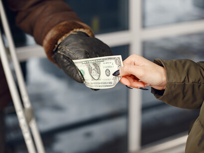 Una banconota da un dollaro passa di mano in un freddo giorno d'inverno