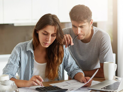 A young couple balancing their family budget amidst the pressures of financial instability and work-related stress