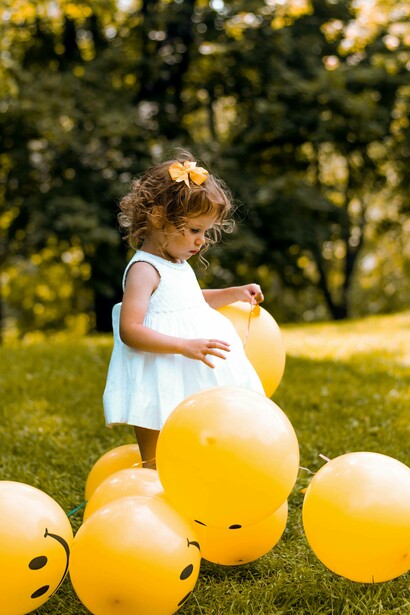 Bimba tra palloncini gialli: “Le capacità motorie si sviluppano attraverso il movimento e il gioco attivo”