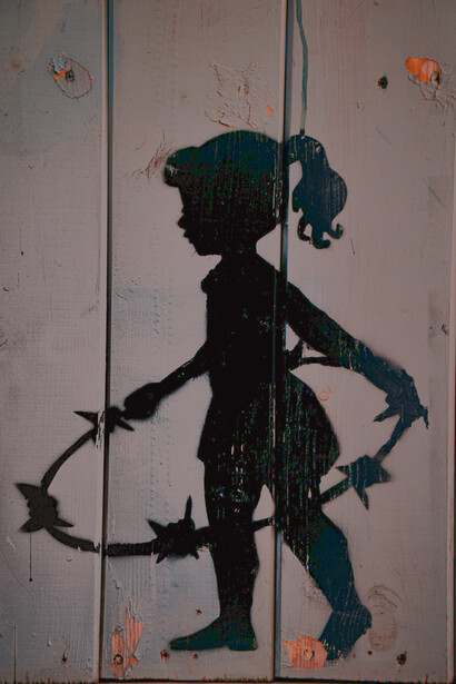Wall art showing a child playing with a barbed wire in Palestine