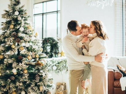 The family gathers together to adorn the Christmas tree with colorful ornaments and twinkling lights