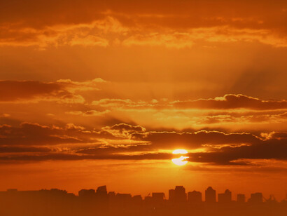 Sun shining over the city; it delivers clean energy in just over eight minutes from 93 million miles away
