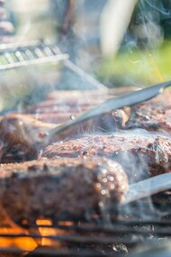 The sizzling fat dripping from the meats of a barbecue