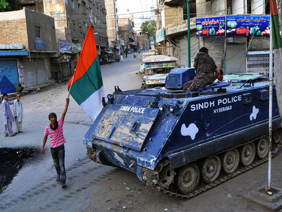 A supporter of Pakistan's Muttahida Qaumi Movement (MQM) party carries a party flag