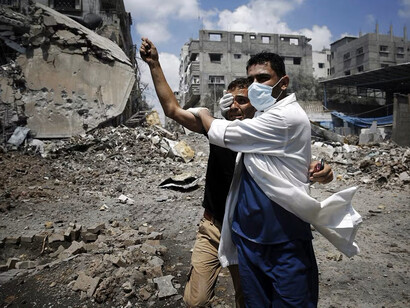 Un médico ayuda a un palestino en el barrio de Shejaia, que fue fuertemente bombardeado por Israel durante los combates, en la ciudad de Gaza el 20 de julio de 2014. Fotografía: Finbarr O’Reilly