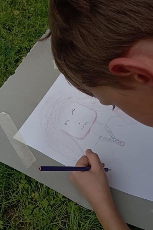 Bambino disegna su un prato secondo il metodo Bimbisvegli di Giampiero Monaca