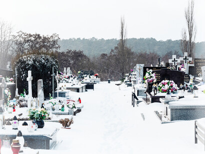 A cemetary covered in snow and flowers; a place people go to 'visit' and honor their loved ones