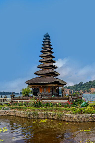 A pagoda reflected in the calm waters of a lake in Bali, Indonesia