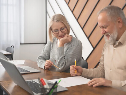 Elderly man and woman actively working on computers