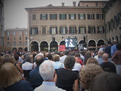 La ciudad cambia radicalmente, las calles del centro se llenan de visitantes, se venden tantos libros, se charla y discute y acuden a ella una serie de personalidades conocidas.  Conferencia de Jeremy Rifkin en el Festival de Filosofía de Modena, Plaza Grande, 2007, Italia