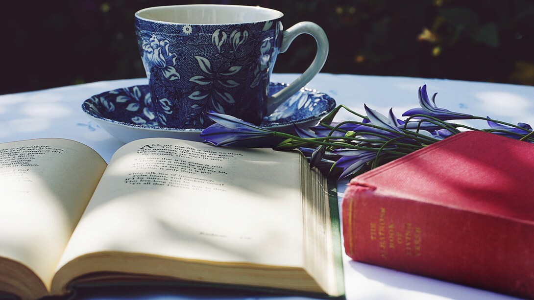 Uma xícara de chá compõem uma harmônica mesa de leituras