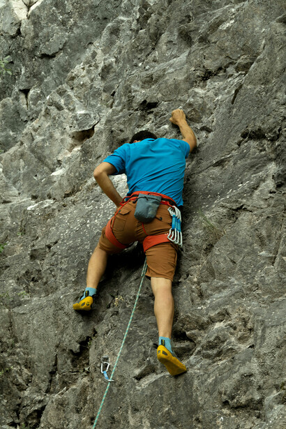 A rock climber steadily climbs a steep cliff in Yalova, Türkiye, embodying concentration and unwavering determination