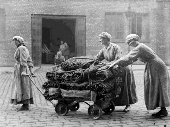 Female workers tow a trolley of raw rubber from a warehouse at the factory of Charles Macintosh and Sons Ltd in Manchester in September 1918, © IWM