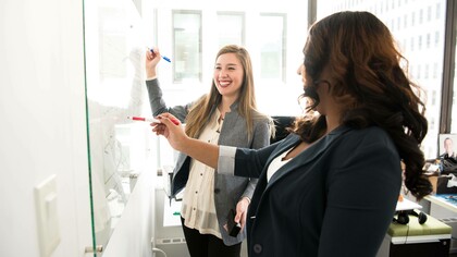 Two women validating their idea buy testing it on a validation board
