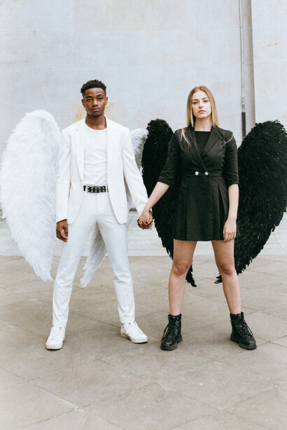 Two angels of light and dark holding hands in unity