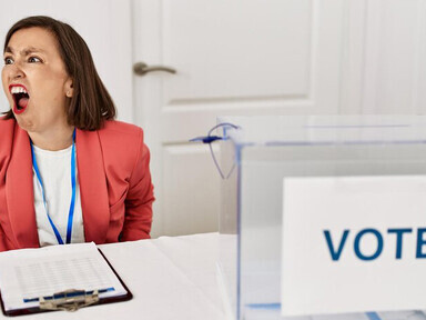 A woman sitting at a ballot station during an election, visibly angry and shouting in frustration, expressing feelings of fury and discontent