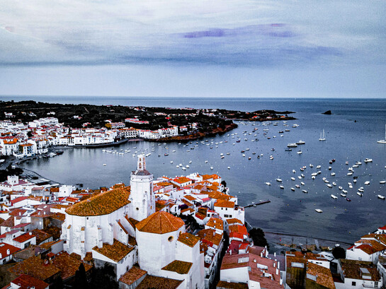 Fishing boats line the waterfront of Cadaqués, Spain, a charming Mediterranean village known for its whitewashed houses and coastal beauty