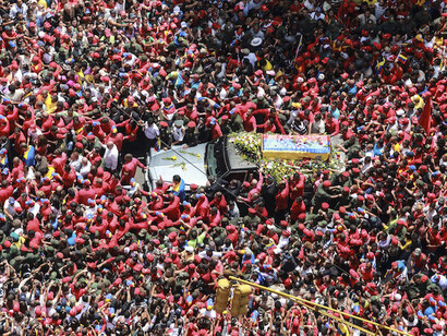 Una multitud rodea el coche fúnebre con el cuerpo de  Hugo Chávez en 2013
