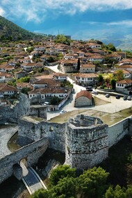The fortified walls of Berat Castle surrounding a historic hillside neighborhood, highlighting the architectural heritage of Berat, Albania