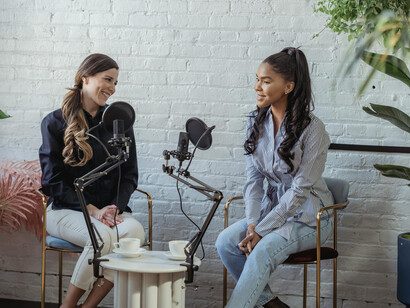 Multiethnic women recording a discussion together in a professional broadcasting studio