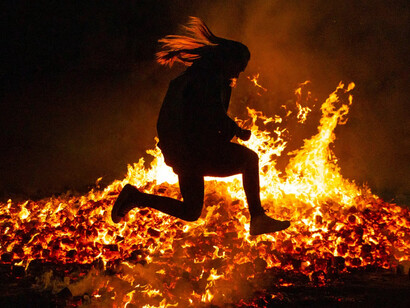 Mujer salta una hogera durante la verbena de San Juan, 2023, España