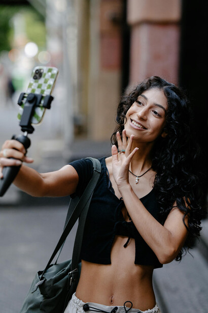 Smiling woman recording herself, representing a travel blogger vlogging