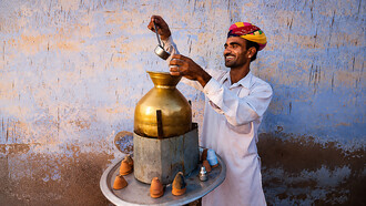Street vendor preparing and serving masala chai in Jaipur, India