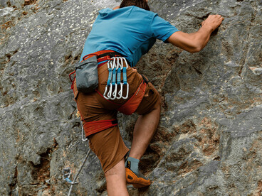 A determined rock climber makes a careful ascent up a steep cliff in Yalova, Türkiye, reflecting focus and resilience