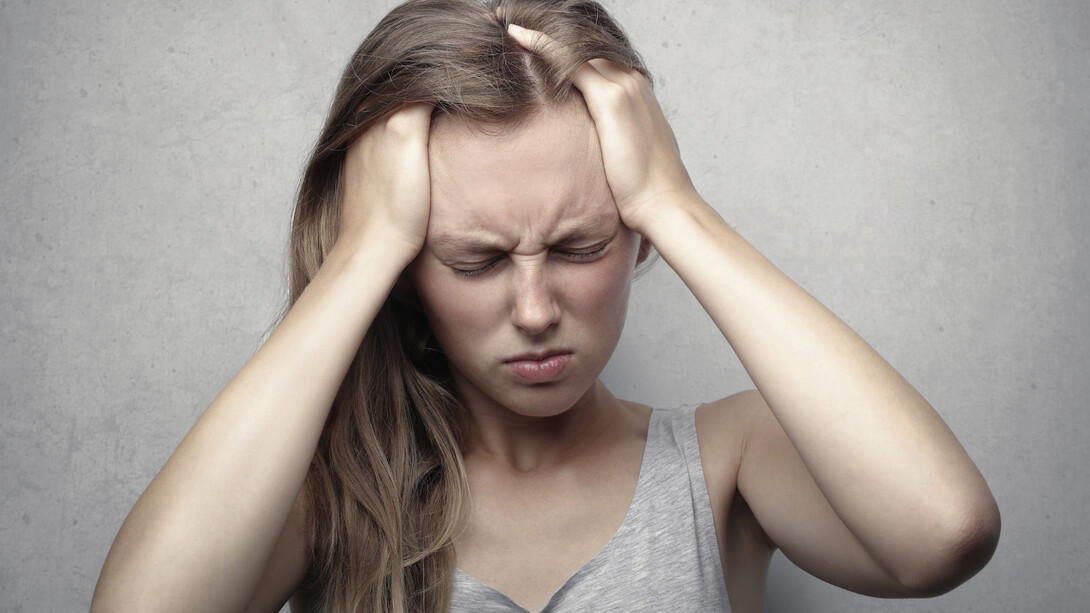 Ragazza si tiene la testa a causa dell'emicrania forte